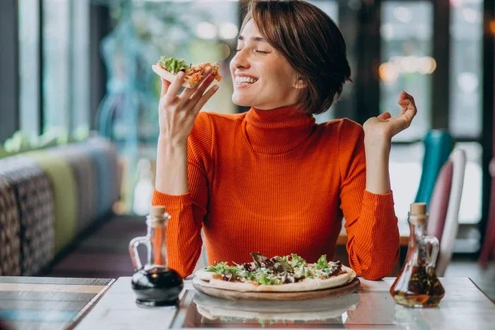 Woman enjoying pizza during an Italian set lunch in Singapore at a cosy restaurant