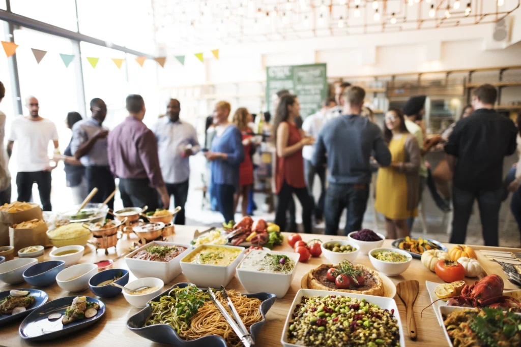 Buffet table with pasta, salads, and Italian dishes at a lively event in Singapore, showcasing Italian cuisine for celebrations and corporate dining.